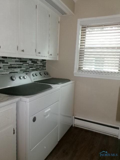 8962 State Route 109, Ottawa, OH 45875 - laundry area with a baseboard heating unit, washing machine and clothes dryer, dark wood finished floors, and cabinet space