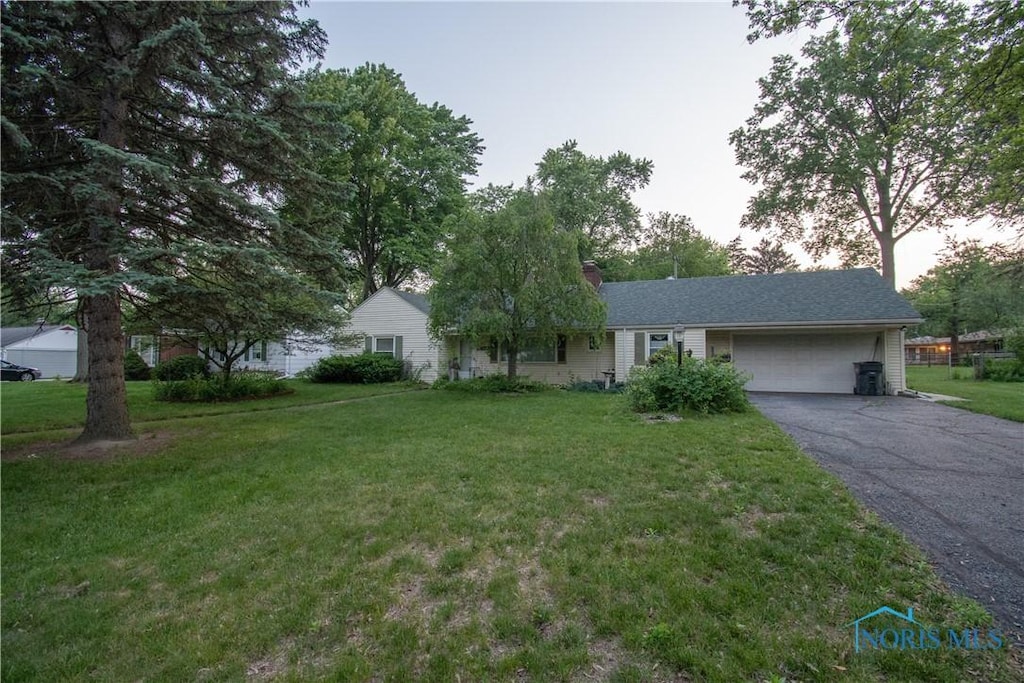 2823 Wicklow Rd, Toledo, OH 43606 - single story home with a garage, asphalt driveway, a front yard, and a chimney