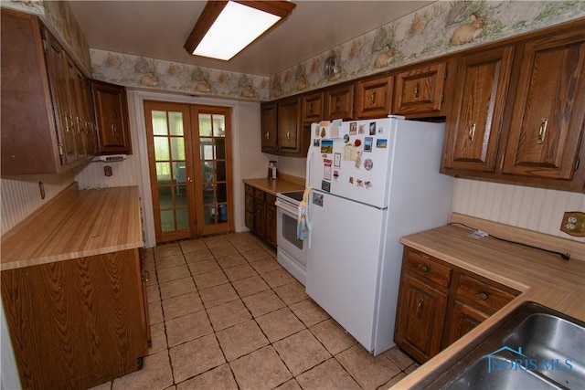 2823 Wicklow Rd, Toledo, OH 43606 - kitchen featuring french doors, white appliances, wallpapered walls, and light tile patterned flooring