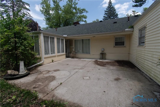 2823 Wicklow Rd, Toledo, OH 43606 - rear view of property featuring a patio, roof with shingles, and a sunroom