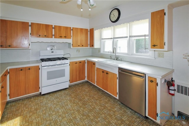 1013 Whittlesey St, Fremont, OH 43420 - kitchen featuring white range with gas cooktop, dishwasher, light countertops, ceiling fan, and radiator heating unit
