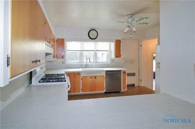 1013 Whittlesey St, Fremont, OH 43420 - kitchen with dishwasher, radiator heating unit, white range with gas stovetop, under cabinet range hood, and light countertops