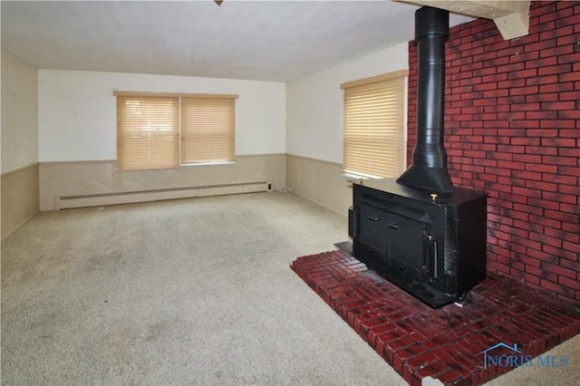 1013 Whittlesey St, Fremont, OH 43420 - unfurnished living room with a baseboard radiator, a wood stove, carpet, and a wainscoted wall