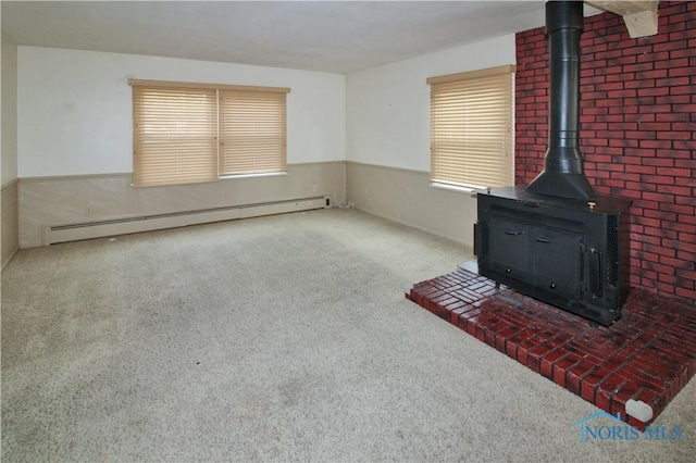 1013 Whittlesey St, Fremont, OH 43420 - unfurnished living room with carpet flooring, a baseboard heating unit, a wainscoted wall, and a wood stove