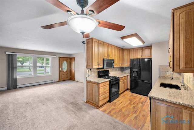 6005 Bahiamar Rd, Toledo, OH 43611 - kitchen featuring black appliances, a baseboard heating unit, ceiling fan, backsplash, and light stone countertops
