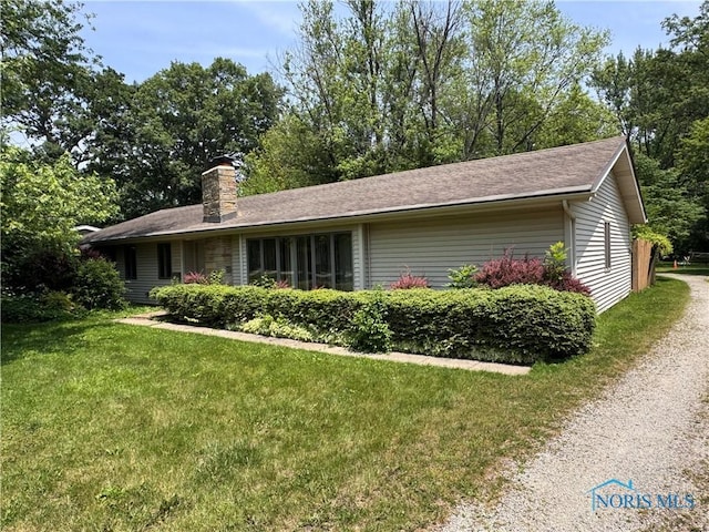 1035 Cherry St, Perrysburg, OH 43551 - view of side of property featuring a lawn, a chimney, and driveway