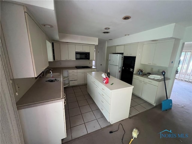 1035 Cherry St, Perrysburg, OH 43551 - kitchen with black appliances, a kitchen island, white cabinetry, and light tile patterned flooring