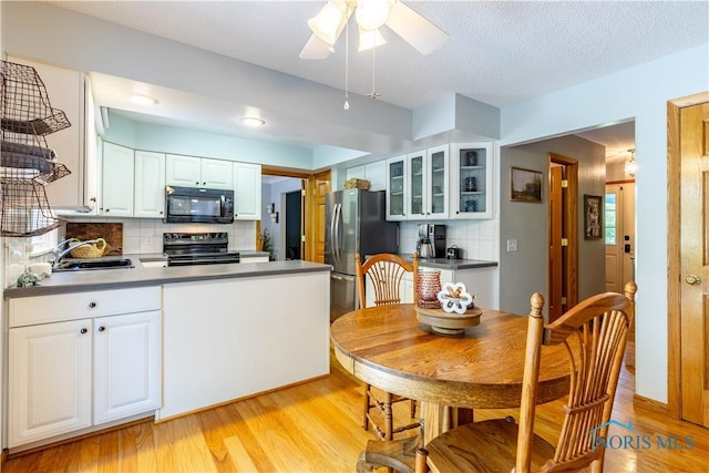 5868 Winslow Rd, Whitehouse, OH 43571 - kitchen with black appliances, glass insert cabinets, decorative backsplash, and light wood-style floors