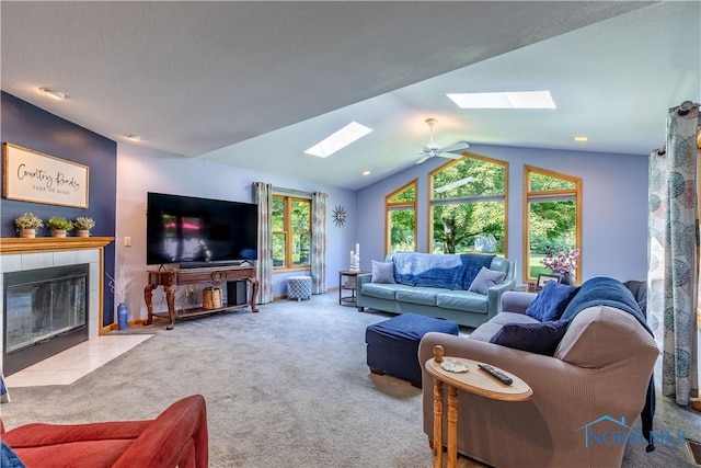 5868 Winslow Rd, Whitehouse, OH 43571 - living room with a skylight, carpet floors, a tiled fireplace, vaulted ceiling, and a ceiling fan