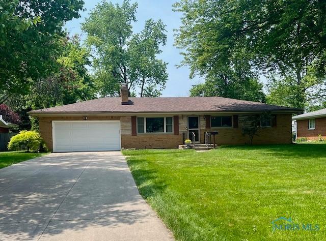 5811 Brainard Dr, Sylvania, OH 43560 - single story home featuring concrete driveway, an attached garage, a front yard, a chimney, and brick siding