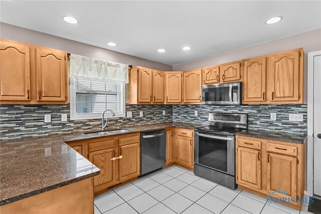 740 Tarra Oaks Dr, Findlay, OH 45840 - kitchen featuring appliances with stainless steel finishes, light tile patterned flooring, backsplash, dark stone countertops, and recessed lighting