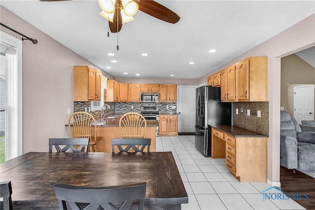 740 Tarra Oaks Dr, Findlay, OH 45840 - kitchen with freestanding refrigerator, stainless steel microwave, ceiling fan, decorative backsplash, and recessed lighting