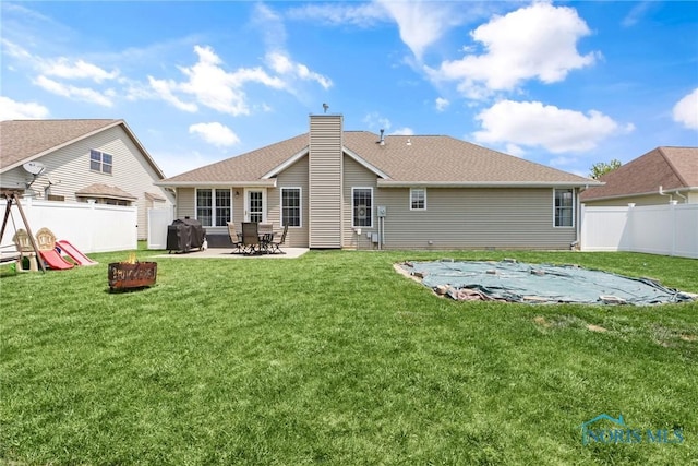740 Tarra Oaks Dr, Findlay, OH 45840 - rear view of house with a fenced backyard, a fire pit, a patio area, and a chimney