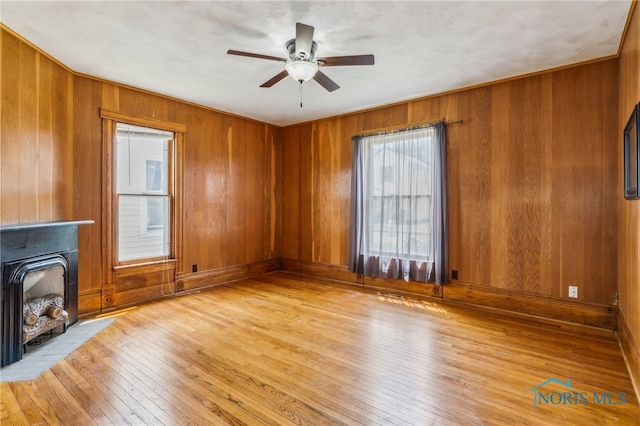 118 Allen Ave, Findlay, OH 45840 - unfurnished living room featuring light wood finished floors, ceiling fan, wooden walls, and a fireplace with flush hearth