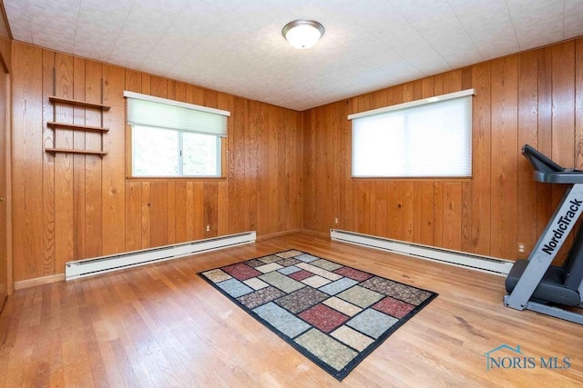 1527 Lockwood Rd, Findlay, OH 45840 - spare room with baseboard heating, plenty of natural light, hardwood / wood-style flooring, and wooden walls