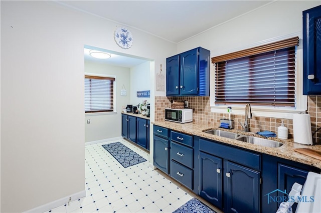 3714 Kershaw Ave, Toledo, OH 43613 - kitchen featuring blue cabinetry, white microwave, light flooring, and tasteful backsplash