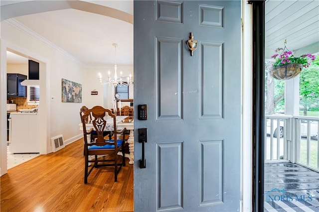 3714 Kershaw Ave, Toledo, OH 43613 - entryway featuring a chandelier, light wood finished floors, plenty of natural light, ornamental molding, and arched walkways