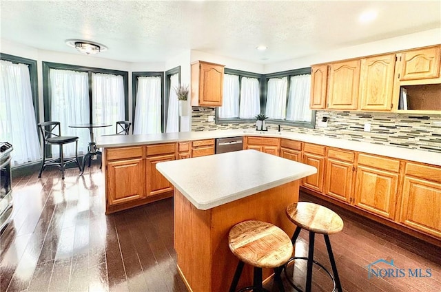 3391 Rd 144, Antwerp, OH 45813 - kitchen with a peninsula, dark wood finished floors, stainless steel dishwasher, tasteful backsplash, and a textured ceiling