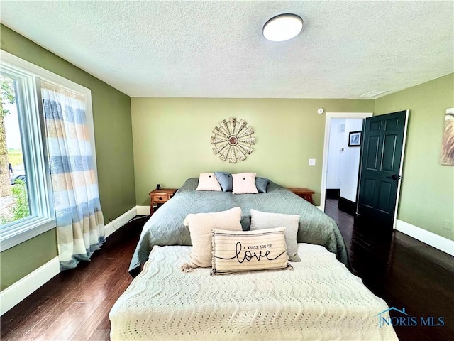 3391 Rd 144, Antwerp, OH 45813 - bedroom featuring a textured ceiling, dark wood-style flooring, and multiple windows