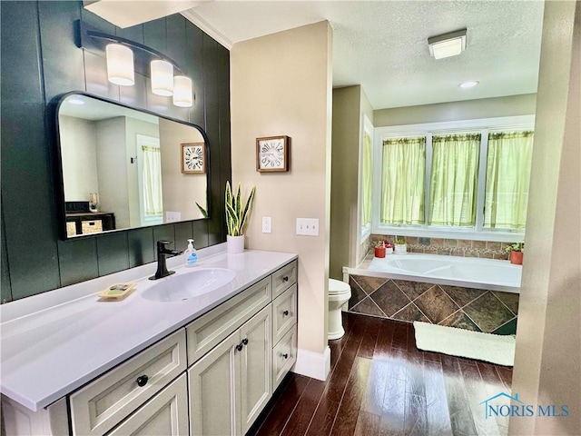 3391 Rd 144, Antwerp, OH 45813 - bathroom featuring hardwood / wood-style flooring, vanity, a garden tub, and a textured ceiling