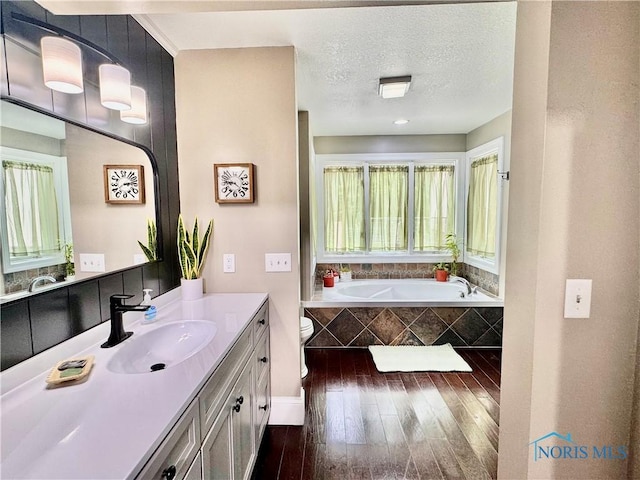 3391 Rd 144, Antwerp, OH 45813 - full bath featuring wood finished floors, vanity, a bath, and a textured ceiling