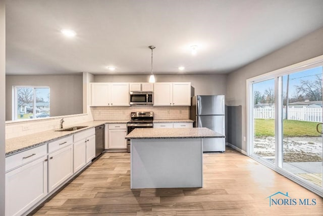 1113 Clairmont Ave, Napoleon, OH 43545 - kitchen featuring appliances with stainless steel finishes, healthy amount of natural light, tasteful backsplash, white cabinets, and recessed lighting