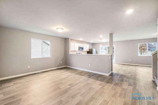 1113 Clairmont Ave, Napoleon, OH 43545 - unfurnished living room featuring light wood finished floors and recessed lighting