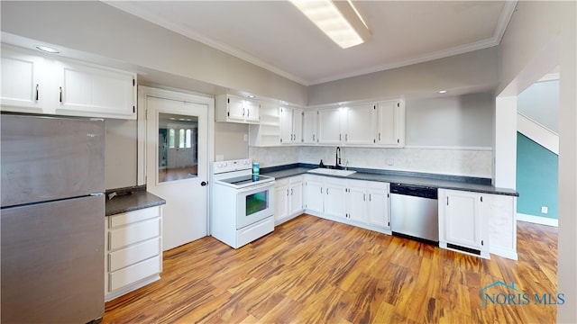628 W Maple St, Clyde, OH 43410 - kitchen featuring appliances with stainless steel finishes, crown molding, dark countertops, white cabinets, and light wood-style floors