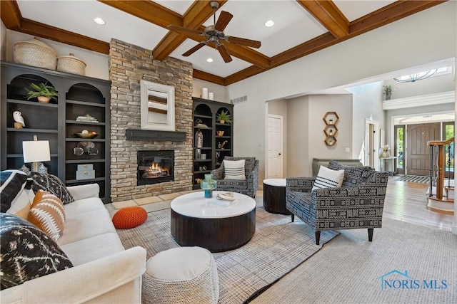 4811 Yosemite Pkwy, Sylvania, OH 43560 - living room with beam ceiling, coffered ceiling, wood finished floors, a ceiling fan, and a stone fireplace