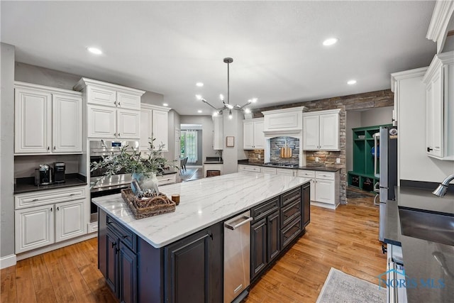 4811 Yosemite Pkwy, Sylvania, OH 43560 - kitchen featuring white cabinetry, stainless steel appliances, a center island, light wood-style floors, and recessed lighting