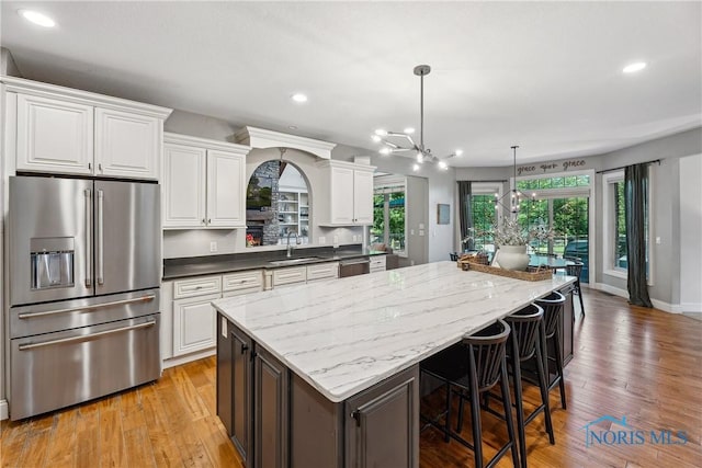 4811 Yosemite Pkwy, Sylvania, OH 43560 - kitchen featuring appliances with stainless steel finishes, a center island, white cabinets, light wood finished floors, and recessed lighting
