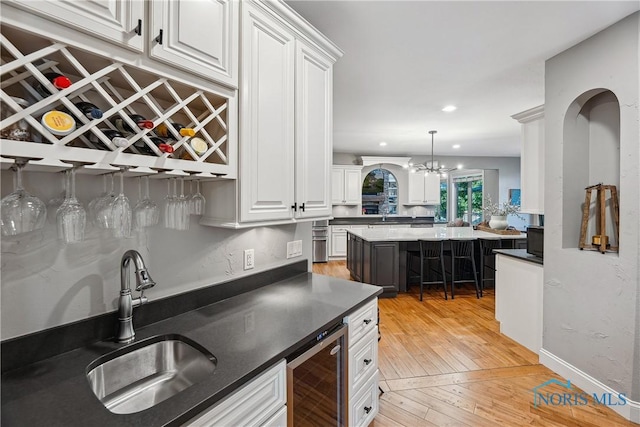 4811 Yosemite Pkwy, Sylvania, OH 43560 - indoor dry bar featuring beverage cooler, light wood finished floors, decorative light fixtures, and recessed lighting