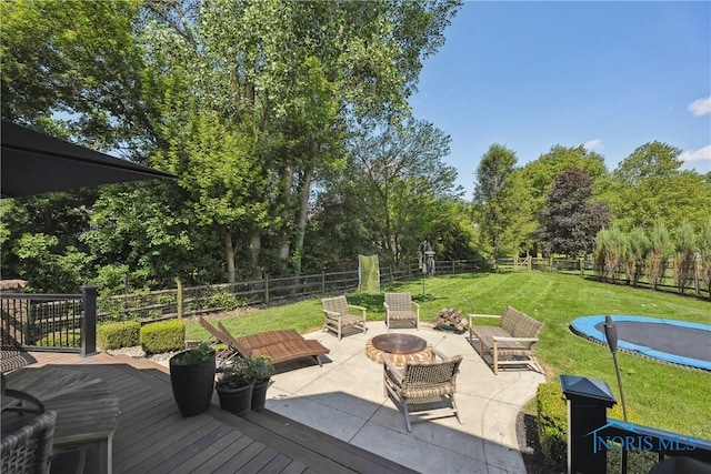 4811 Yosemite Pkwy, Sylvania, OH 43560 - fenced backyard featuring a fire pit, a patio area, a wooden deck, and a trampoline