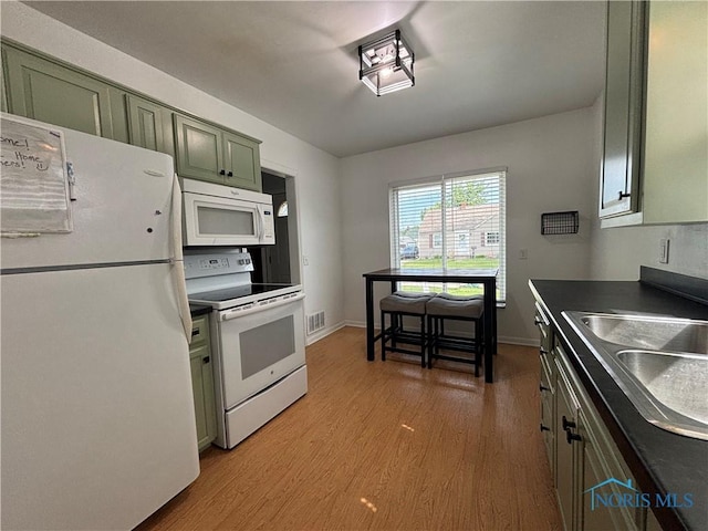 2914 118th St, Toledo, OH 43611 - kitchen with white appliances, green cabinets, light wood finished floors, and dark countertops