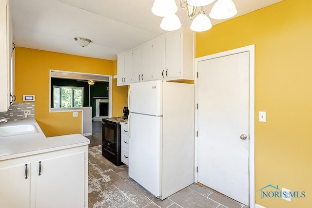 1040 Richland St, Maumee, OH 43537 - kitchen with freestanding refrigerator, black electric range oven, white cabinets, a chandelier, and light countertops