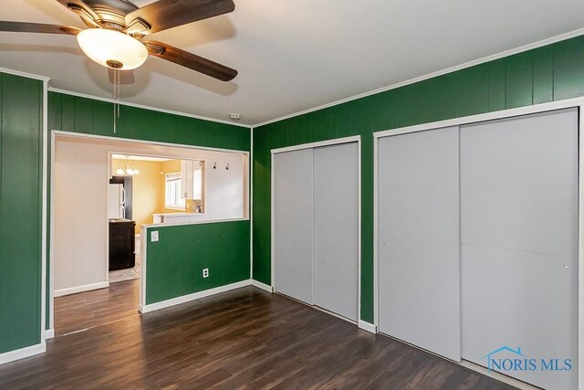 1040 Richland St, Maumee, OH 43537 - unfurnished bedroom featuring multiple closets, ornamental molding, freestanding refrigerator, dark wood finished floors, and a ceiling fan