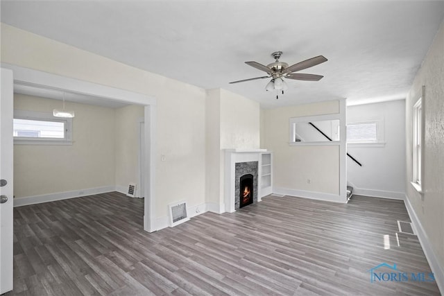 3504 Willys Pkwy, Toledo, OH 43612 - unfurnished living room with wood finished floors, a warm lit fireplace, and a ceiling fan