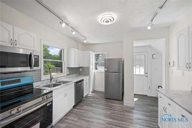 3504 Willys Pkwy, Toledo, OH 43612 - kitchen featuring appliances with stainless steel finishes, track lighting, decorative backsplash, white cabinets, and a textured ceiling