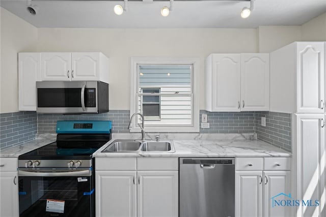 3504 Willys Pkwy, Toledo, OH 43612 - kitchen with appliances with stainless steel finishes, white cabinetry, and decorative backsplash