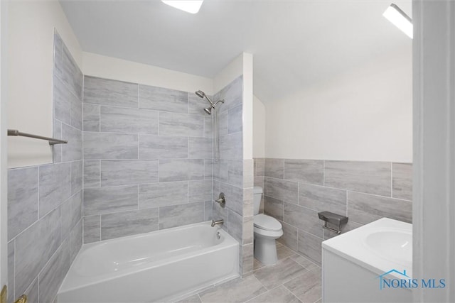 3504 Willys Pkwy, Toledo, OH 43612 - full bathroom with tile walls, vanity, shower / washtub combination, wainscoting, and tile patterned flooring