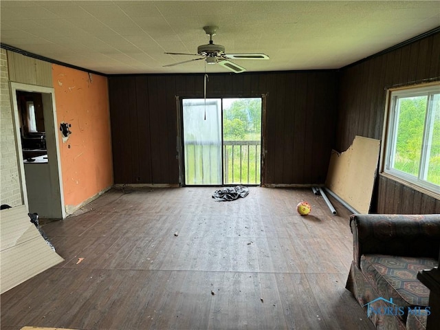 1447 US Highway 20, Edon, OH 43518 - unfurnished living room featuring hardwood / wood-style floors, a ceiling fan, and wooden walls