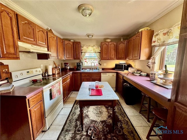 121 Columbus St, Hicksville, OH 43526 - kitchen featuring under cabinet range hood, white appliances, ornamental molding, brown cabinetry, and light tile patterned floors