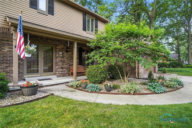 4329 Woodbriar Dr, Toledo, OH 43623 - view of exterior entry with brick siding, french doors, a porch, and a garage