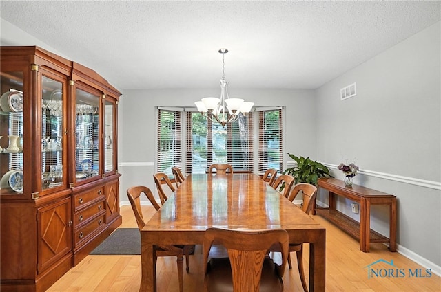 4329 Woodbriar Dr, Toledo, OH 43623 - dining space with a chandelier, light wood-style floors, and a textured ceiling