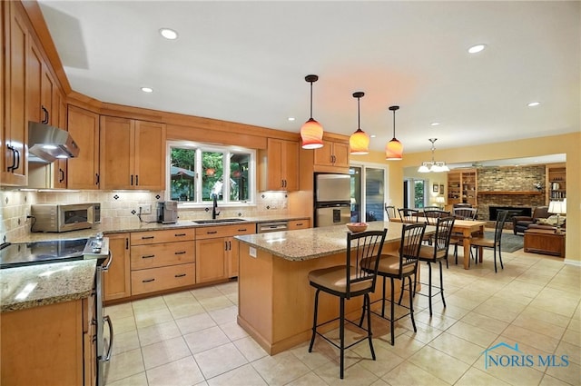 4329 Woodbriar Dr, Toledo, OH 43623 - kitchen with stainless steel appliances, under cabinet range hood, tasteful backsplash, light tile patterned floors, and light stone counters
