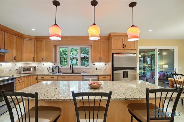 4329 Woodbriar Dr, Toledo, OH 43623 - kitchen with appliances with stainless steel finishes, a kitchen breakfast bar, backsplash, under cabinet range hood, and recessed lighting
