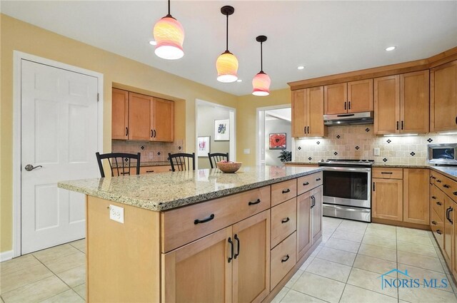 4329 Woodbriar Dr, Toledo, OH 43623 - kitchen featuring stainless steel appliances, under cabinet range hood, a center island, light tile patterned floors, and tasteful backsplash