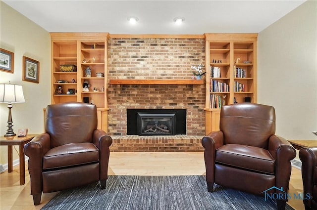 4329 Woodbriar Dr, Toledo, OH 43623 - sitting room with built in shelves, wood finished floors, and a fireplace