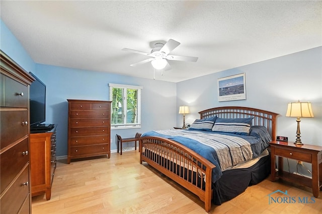 4329 Woodbriar Dr, Toledo, OH 43623 - bedroom with light wood-type flooring, ceiling fan, and a textured ceiling