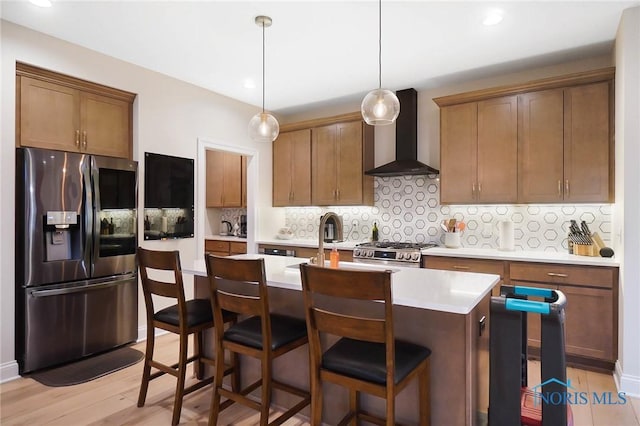 1635 Winterwood Ct, Bowling Green, OH 43402 - kitchen with appliances with stainless steel finishes, wall chimney exhaust hood, light countertops, a kitchen island with sink, and tasteful backsplash